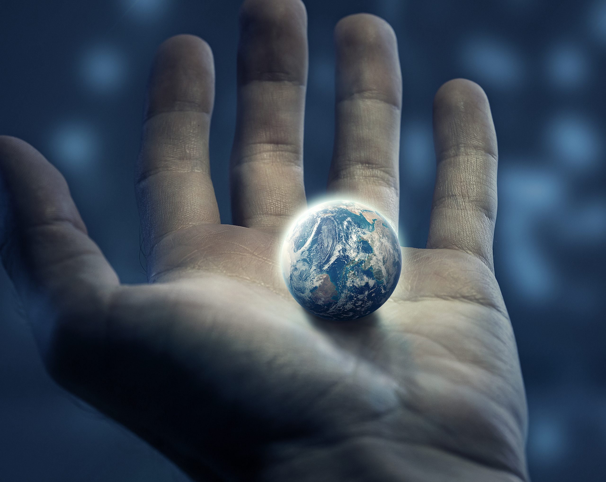 An outstretched hand holding the earth, symbolizing care for both the societal and individual worlds.